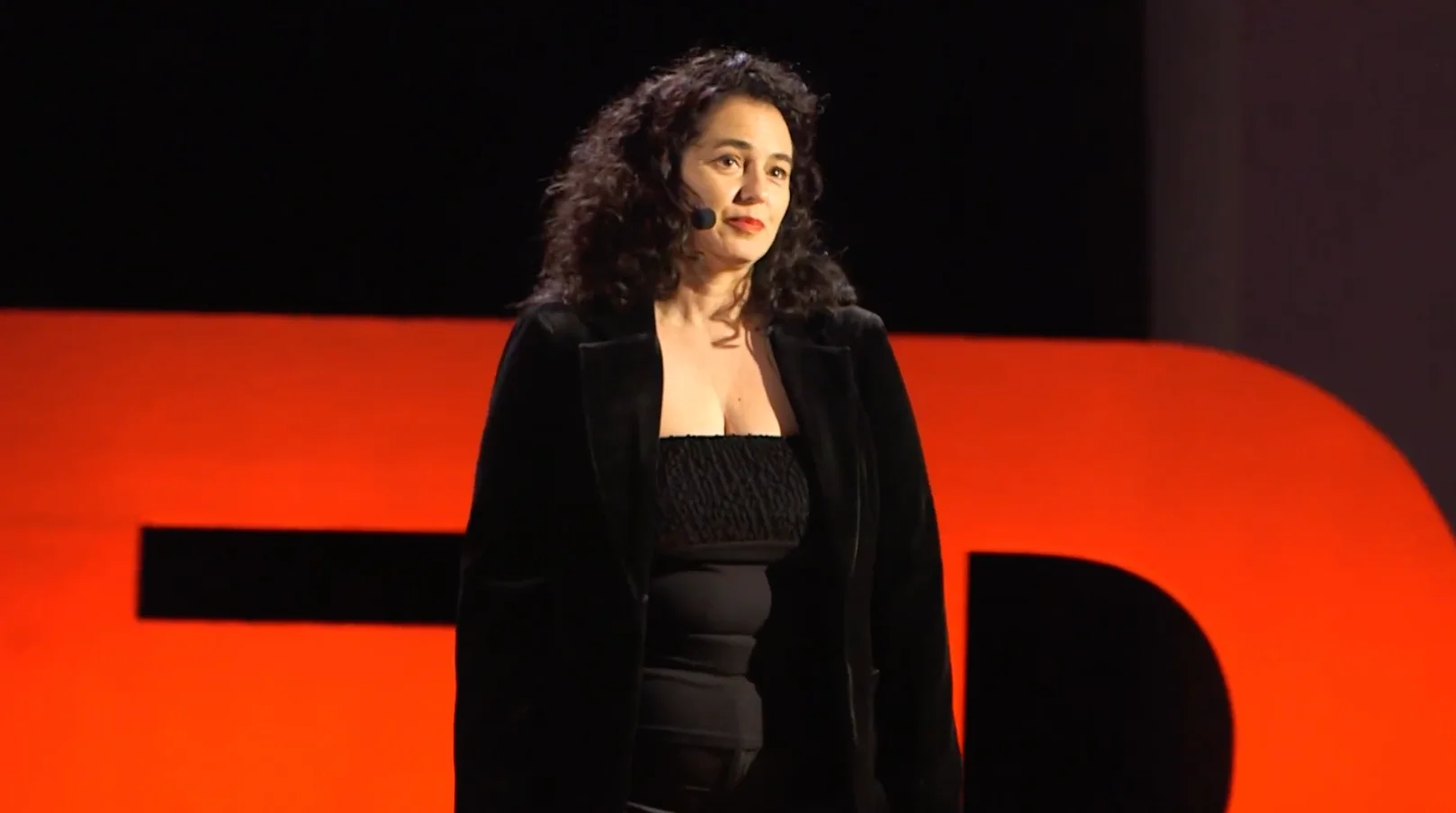 Katalin Orosz pe scena TEDxTârgu Mureș, în fața literelor TEDx roșii